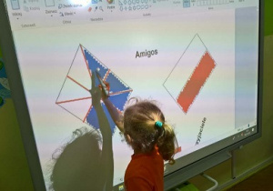 Zdjęcie przedstawia dziewczynkę, która koloruje on - line flagę Wielkiej Brytanii tworząć logo do projektu.